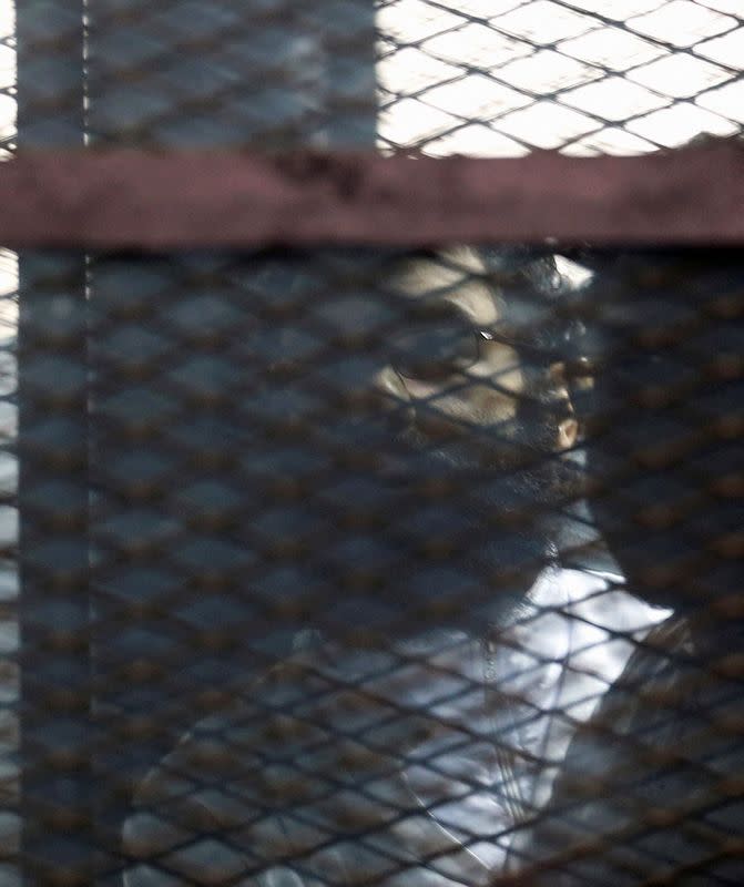 FILE PHOTO: Activist Alaa Abdel Fattah stands behind bars before his verdict is announced at a court in Cairo