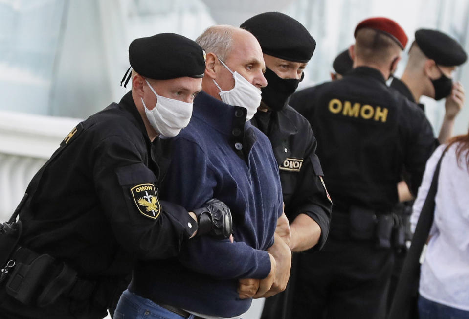 Police officers detain a protester during a rally against the removal of opposition candidates from the presidential elections in Minsk, Belarus, Tuesday July 14, 2020. Election authorities in Belarus on Tuesday barred two main rivals of authoritarian leader Alexander Lukashenko from running in this summer's presidential election. (AP Photo/Sergei Grits)