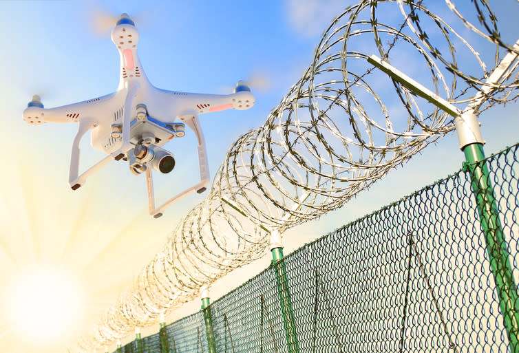 <span class="caption">Would robot wardens patrol robot jails?</span> <span class="attribution"><a class="link " href="https://www.shutterstock.com/image-photo/drone-monitoring-barbed-wire-fence-on-562264267?src=isb7kjpWe7kvF0hy2qq4og-1-0" rel="nofollow noopener" target="_blank" data-ylk="slk:Shutterstock;elm:context_link;itc:0;sec:content-canvas">Shutterstock</a></span>