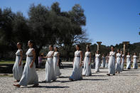 Actresses, playing the role of priestesses, performance during the flame lighting ceremony at the closed Ancient Olympia site, birthplace of the ancient Olympics in southern Greece, Thursday, March 12, 2020, 2020. Greek Olympic officials are holding a pared-down flame-lighting ceremony for the Tokyo Games due to concerns over the spread of the coronavirus. Both Wednesday's dress rehearsal and Thursday's lighting ceremony are closed to the public, while organizers have slashed the number of officials from the International Olympic Committee and the Tokyo Organizing Committee, as well as journalists at the flame-lighting. (AP Photo/Thanassis Stavrakis)