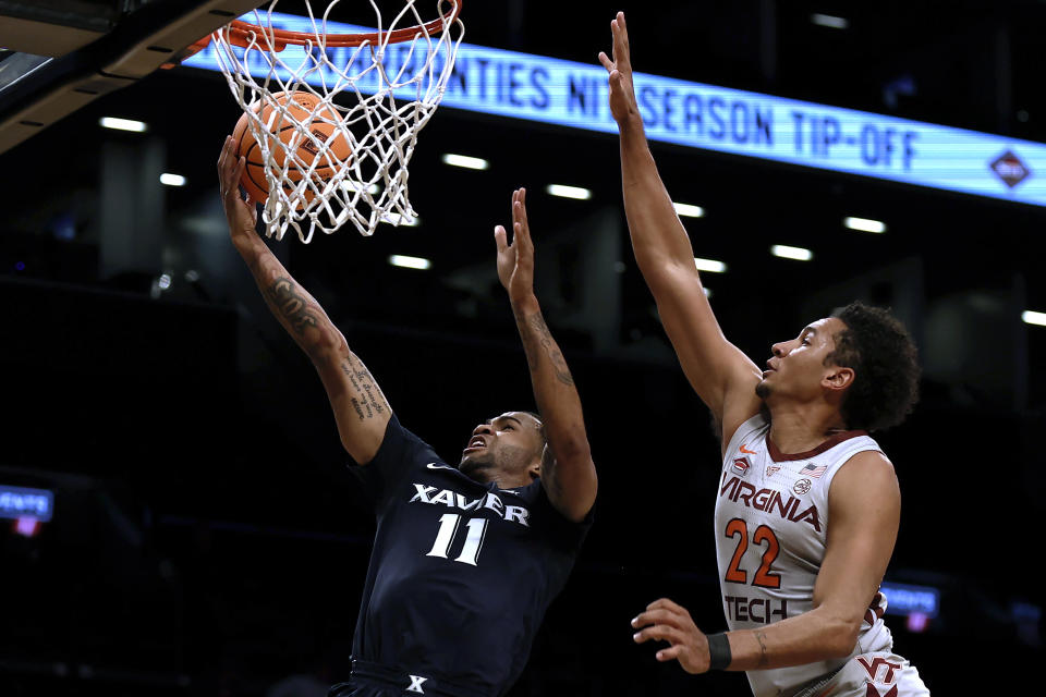 Xavier's Dwon Odom (11) drives to the basket past Virginia Tech's Keve Aluma (22) during the first half of an NCAA college basketball game in the NIT Season Tip-Off tournament Friday, Nov. 26, 2021, in New York. (AP Photo/Adam Hunger)