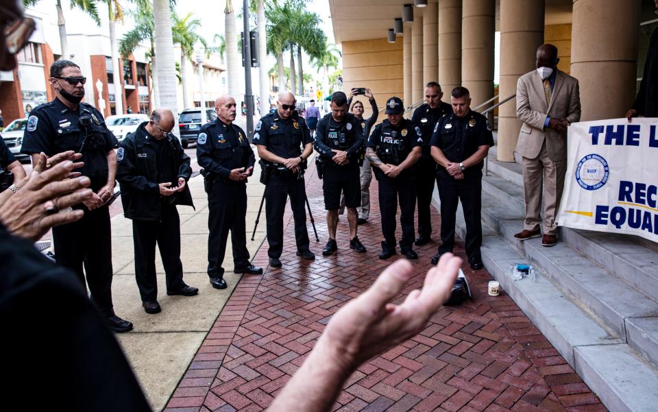 Members of local law enforcement agencies including the Fort Myers Police Department, The Cape Coral Police Department and others take part in a candlelight vigil at the Federal Courthouse in downtown Fort Myers on Wednesday, Jan. 26, 2022. The local chapter of the NAACP held the vigil to promote unity among law enforcement and the community. They held the event in light of the recent police shootings in New York.  On the far right is James Muwakkil, president of the local chapter of the NAACP.