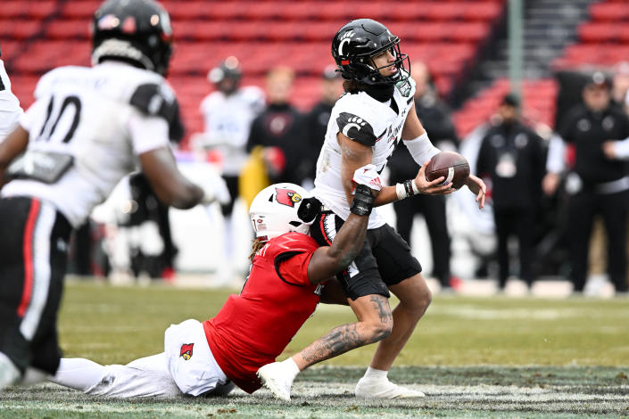 BOSTON, MASSACHUSETTS - DECEMBER 17: Linebacker Monty Montgomery #7 of the Louisville Cardinals sacks quarterback Evan Prater #3 of the Cincinnati Bearcats during the first quarter of the Wasabi Fenway Bowl at Fenway Park on December 17, 2022 in Boston, Massachusetts. (Photo by Brian Fluharty/Getty Images)