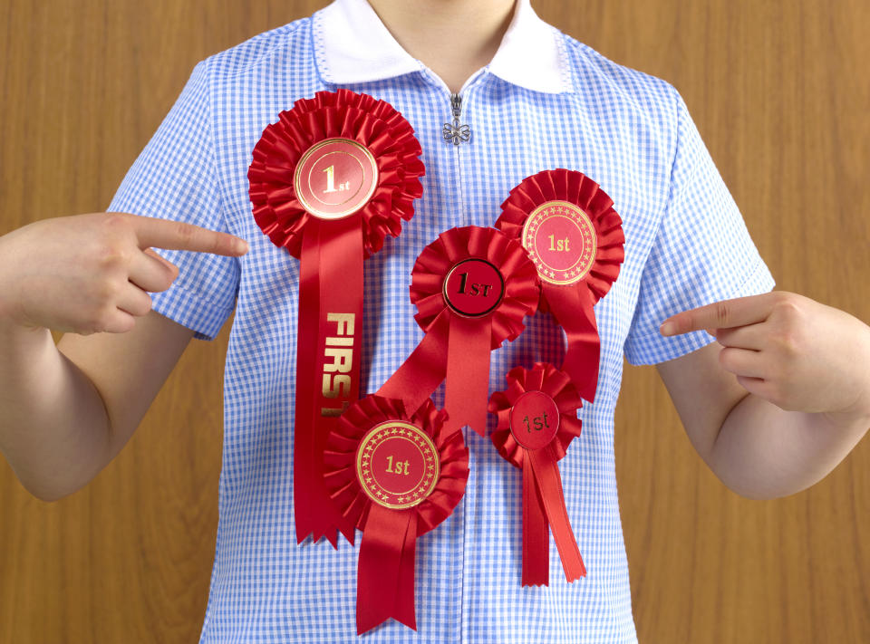 a guy with a bunch of 1st place ribbons on him