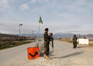 An Afghan National Army (ANA) soldier stands guard at a checkpoint outside Bagram prison, ahead of the release of 100 Taliban prisoners, north of Kabul