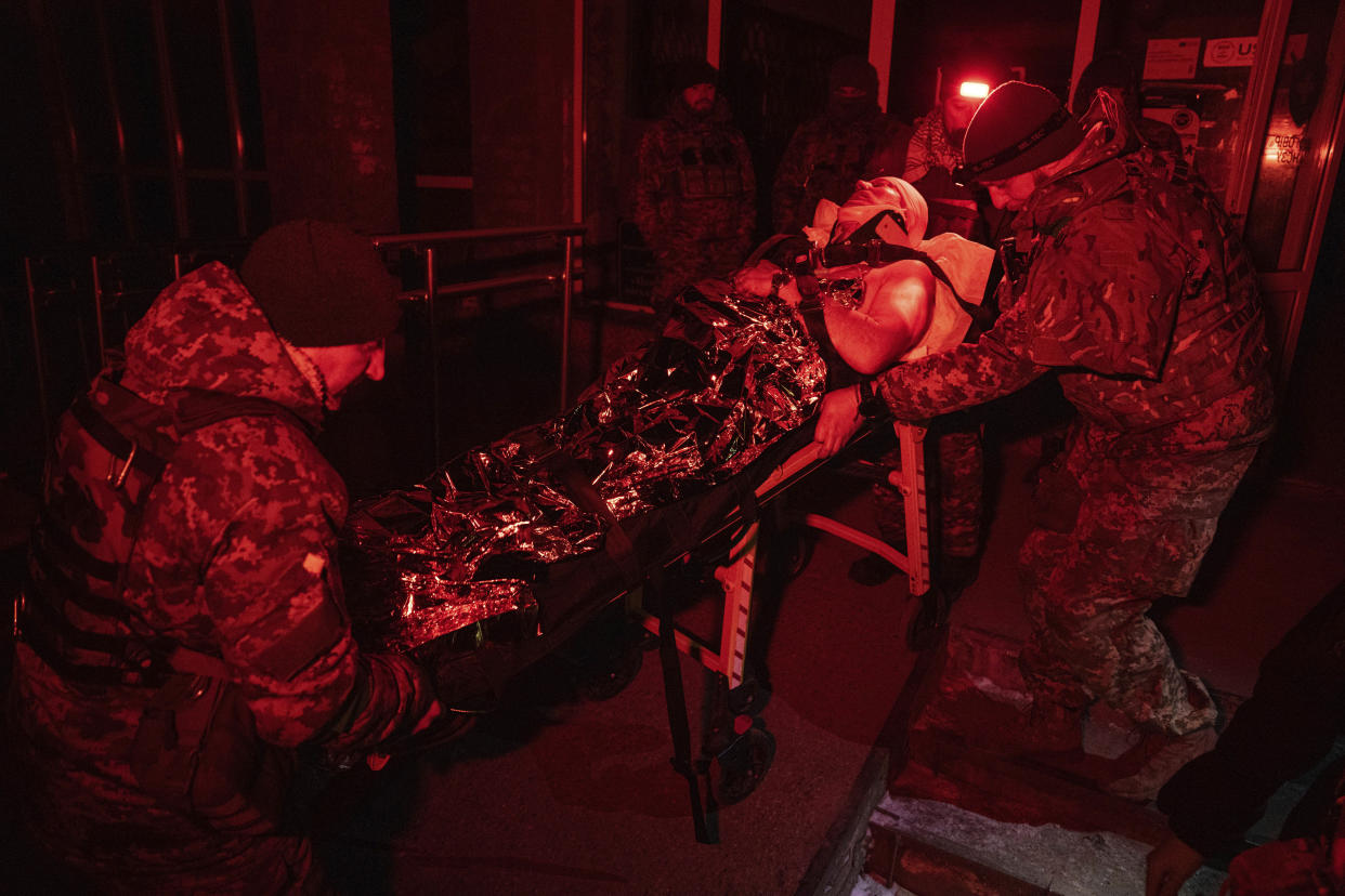 Ukrainian military medics transport their injured comrade evacuated from the battlefield into a hospital in Donetsk region, Ukraine, Monday, Jan. 9, 2023. (AP Photo/Evgeniy Maloletka)