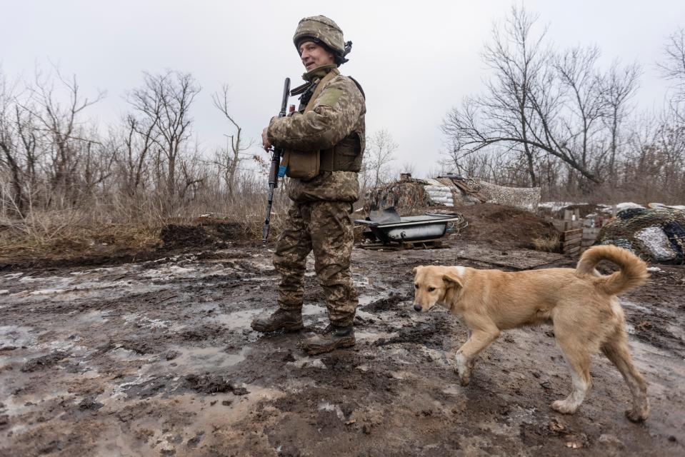 A Ukrainian soldier walks on the line of separation from pro-Russian rebels, Donetsk region, Ukraine, Monday, Jan. 10, 2022. President Joe Biden has warned Russia's Vladimir Putin that the U.S. could impose new sanctions against Russia if it takes further military action against Ukraine