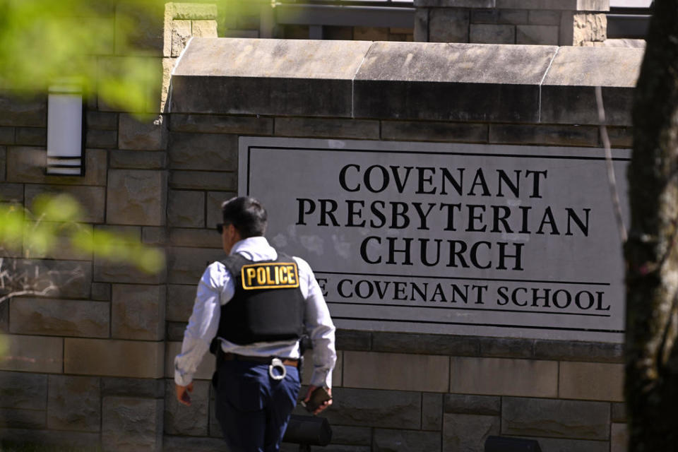 A police officer walks by an entrance to The Covenant School after a shooting in Nashville, Tenn. on Monday, March 27, 2023. / Credit: John Amis / AP