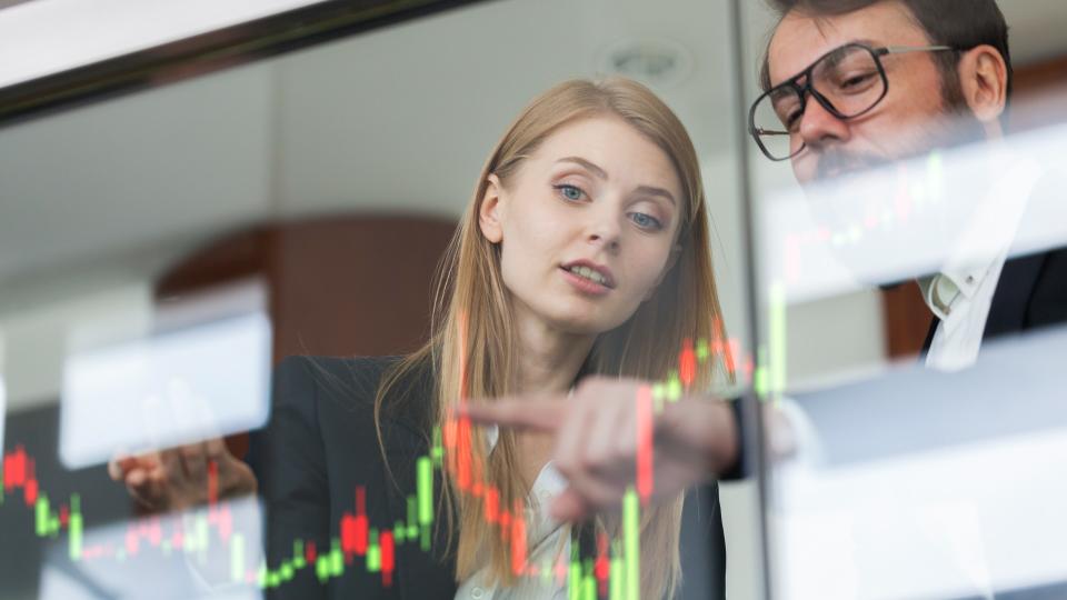 Businesswoman and businessman talking profit on  futuristic display.