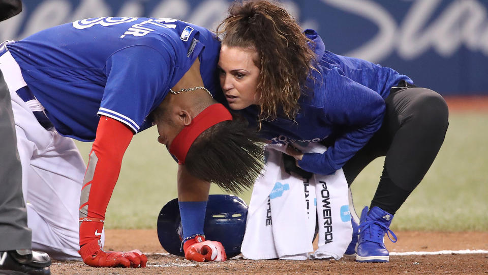 TORONTO, ON - SEPTEMBER 7: Head athletic trainer Nikki Huffman tends to Lourdes Gurriel Jr. #13 of the Toronto Blue Jays after he was hit by pitch in the tenth inning during MLB game action against the Cleveland Indians at Rogers Centre on September 7, 2018 in Toronto, Canada. (Photo by Tom Szczerbowski/Getty Images) 
