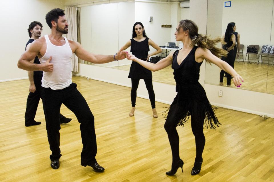 FILE - In this June 28, 2013 photo, dancers Karina Smirnoff, right, and Maksim Chmerkovskiy rehearse for the upcoming Broadway show "Forever Tango" as Juan Horvath, background left, and Victoria Galoto, look on in New York. Smirnoff and Chmerkovskiy, best known for their work on "Dancing with the Stars," will star in the revival of Luis Bravo's "Forever Tango," which traces the dance's birth on the streets of 19th-century Buenos Aires to its more modern manifestations. (Photo by Charles Sykes/Invision/AP, File)