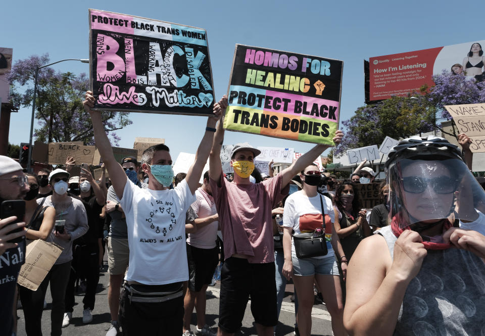 LGBTQ community members raise signs and join in support of Black Lives Matter during a protest at an intersection in West Hollywood, Calif. on Wednesday, June 3, 2020, over the death of George Floyd. Floyd died after being restrained by Minneapolis police officers on Memorial Day. (AP Photo/Richard Vogel)