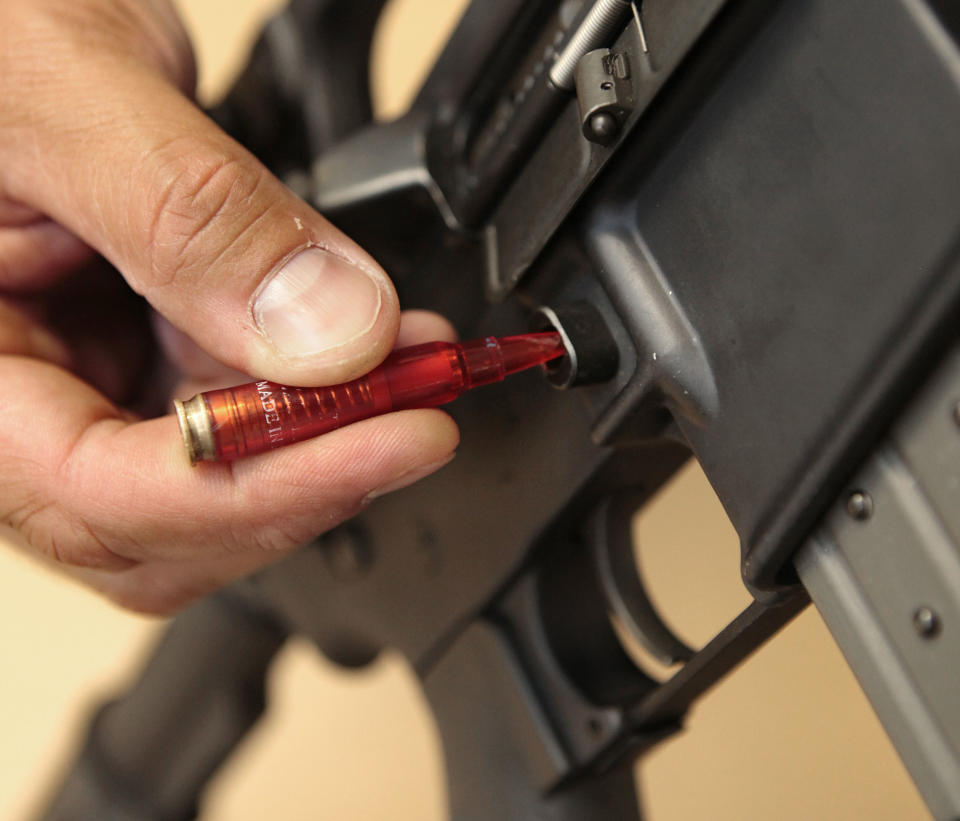 In this photo taken Wednesday, Aug. 15, 2012, A plastic replica of a bullet is used to quickly remove a ammunition magazine from an assault rifle in a demonstration at the California Department of Justice in Sacramento, Calif. Current law requires some type of tool, even something like a bullet, be used when reloading. State Sen. Leland Yee, D-San Francisco, is proposing to change California law to make it more difficult and time-consuming to reload. The proposed measure is one of a number of gun control laws being introduced in some the nations most populous states after the recent shootings in Colorado.(AP Photo/Rich Pedroncelli)