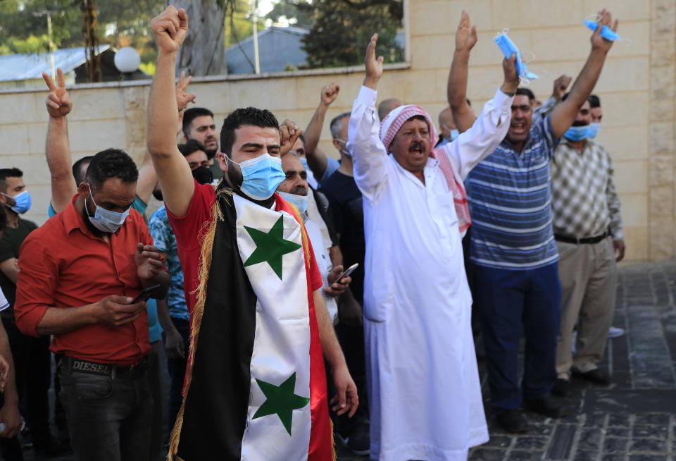 Syrian citizens who live in Lebanon shout pro-Syrian President Bashar Assad slogans, as they wait to cast their ballots for their country's presidential election at the Syrian embassy in Yarze, east of Beirut, Lebanon, Thursday, May 20, 2021. The expat ballot started in embassies abroad ahead of Syria's May 26 presidential election. (AP Photo/Hussein Malla)