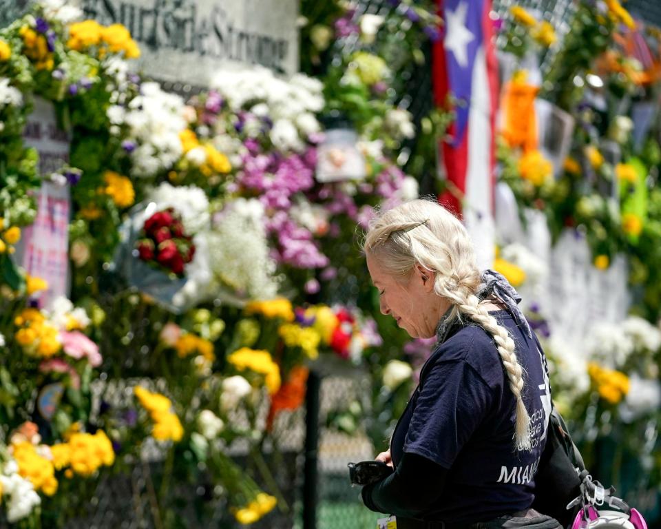 Dr. Alison Thompson, with the search and rescue team, prays at the Surfside Wall of Hope and Memorial near the site of the Champlain Towers South building collapse in Surfside, Fla., on Friday, July 2, 2021. "I feel like we're standing in the gates of September 11th, the gates of hell all over again but this time we can't find the door in," said Thompson, who also worked on the search and rescue team after the 9/11 World Trade Center attack. "We just want to find the stolen lives of Miami." Search and rescue efforts continue into the second week.