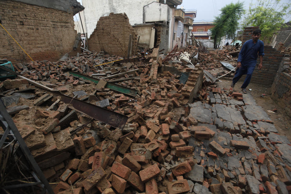 A man walks through the rubble of a damaged house caused by a powerful earthquake that struck Sahang Kikri village near Mirpur, in northeast Pakistan, Wednesday, Sept. 25, 2019. A powerful earthquake struck northeast Pakistan Tuesday, badly damaging scores of home and shops and killing some people and injured over 700, officials, said. (AP Photo/Anjum Naveed)