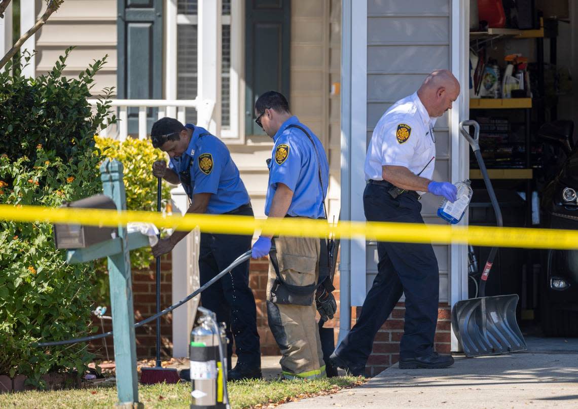 Raleigh firefighters clean the porch and sidewalk at 5355 Sahalee Way on Friday, October 14, 2022 in Raleigh, N.C., after the killing of five people yesterday in the Hedingham neighborhood including an off-duty police officer.