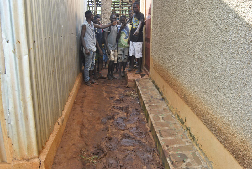 Villagers point to footprints in the mud outside a small house where they claimed the suspected kidnappers of an Italian woman had been staying in recently, in the village of Chakama, in coastal Kilifi county, Kenya Wednesday, Nov. 21, 2018. Gunmen shot indiscriminately, kidnapped the Italian woman and wounded a number of Kenyans late Tuesday according to police. (AP Photo)