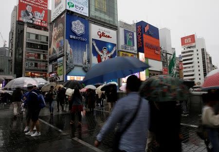 Shoppers walk under umbrellas as Typhoon Lan approaches Japan's mainland, in Osaka, western Japan, October 22, 2017. REUTERS/Thomas White
