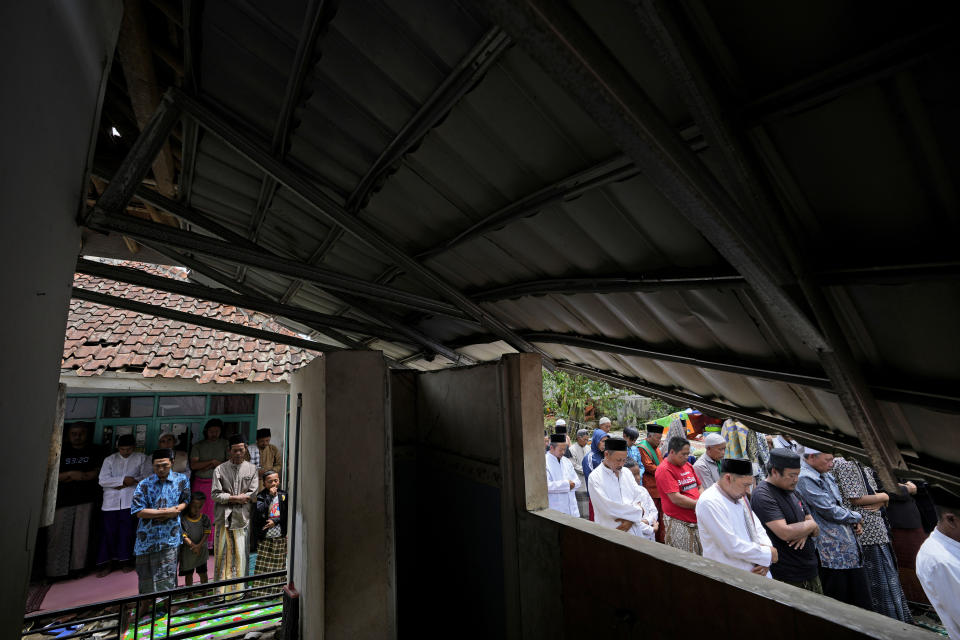 Muslim men perform a Friday prayer outside a mosque damaged in Monday's earthquake in Gasol village, Cianjur, West Java, Indonesia, Friday, Nov. 25, 2022. The magnitude 5.6 quake on Monday killed hundreds of people, many of them children and injured thousands. (AP Photo/Achmad Ibrahim)