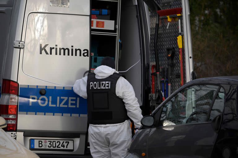 Un policía detrás del coche de los expertos forenses durante una redada el 7 de diciembre de 2022 en Berlín, que forma parte de las redadas nacionales de madrugada contra miembros de un "grupo terrorista" de extrema derecha sospechosos de planear un atentado.