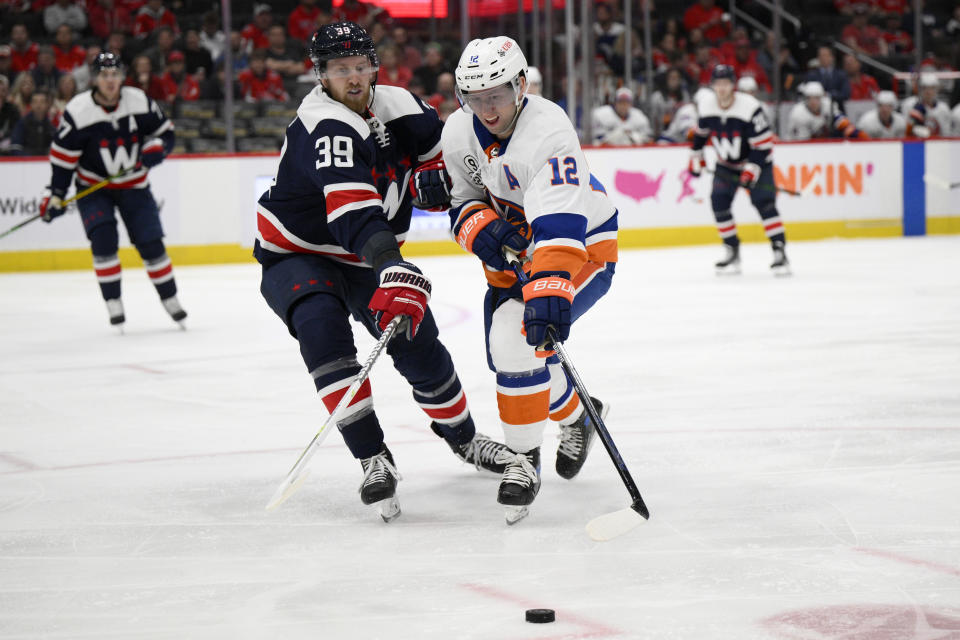 New York Islanders right wing Josh Bailey (12) and Washington Capitals right wing Anthony Mantha (39) battle for the puck during the second period of an NHL hockey game, Tuesday, April 26, 2022, in Washington. (AP Photo/Nick Wass)