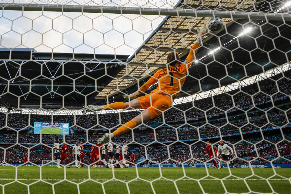 England's goalkeeper Jordan Pickford fails tome a save against shot by Denmark's Mikkel Damsgaard during the Euro 2020 soccer championship semifinal match between England and Denmark at Wembley Stadium in London, Wednesday, July 7, 2021. (AP Photo/Frank Augstein)