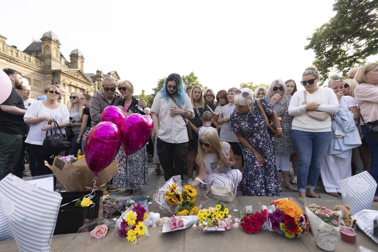 Members of the public take part in a vigil near the scene in Hart Street, in Southport, England, Tuesday, July 30, 2024, where three children died and eight were injured in a knife attack during a Taylor Swift event at a dance school on Monday. (James Speakman/PA via AP)