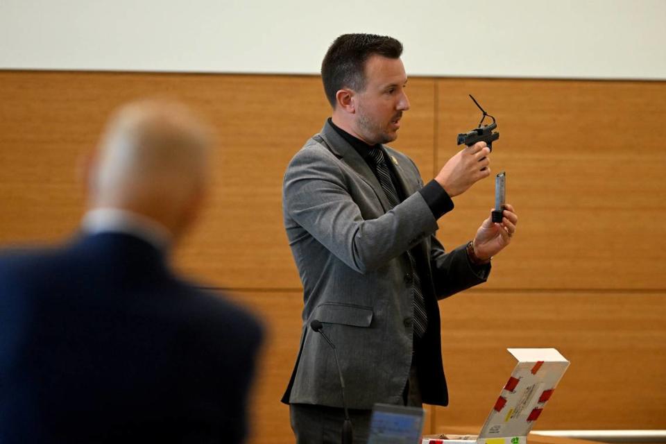 Daniel Hausdorf, crime laboratory analyst for Florida Department of Law Enforcement holds the Sprinfield armory 45 automatic pistol which was used to kill Doug Benefield on the third day of Ashley Benefield’s trial for the second-degree murder of her husband, Doug Benefield, in 2020 at the Manatee County Judicial Center, July 25, 2024.