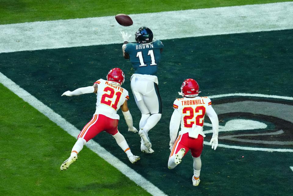 Feb 12, 2023; Glendale, AZ, USA; Philadelphia Eagles wide receiver A.J. Brown (11) catches a touchdown pass against Kansas City Chiefs cornerback Trent McDuffie (21) and safety Juan Thornhill (22) during the first half in Super Bowl LVII at State Farm Stadium. Mandatory Credit: Patrick Breen/The Republic via USA TODAY Sports