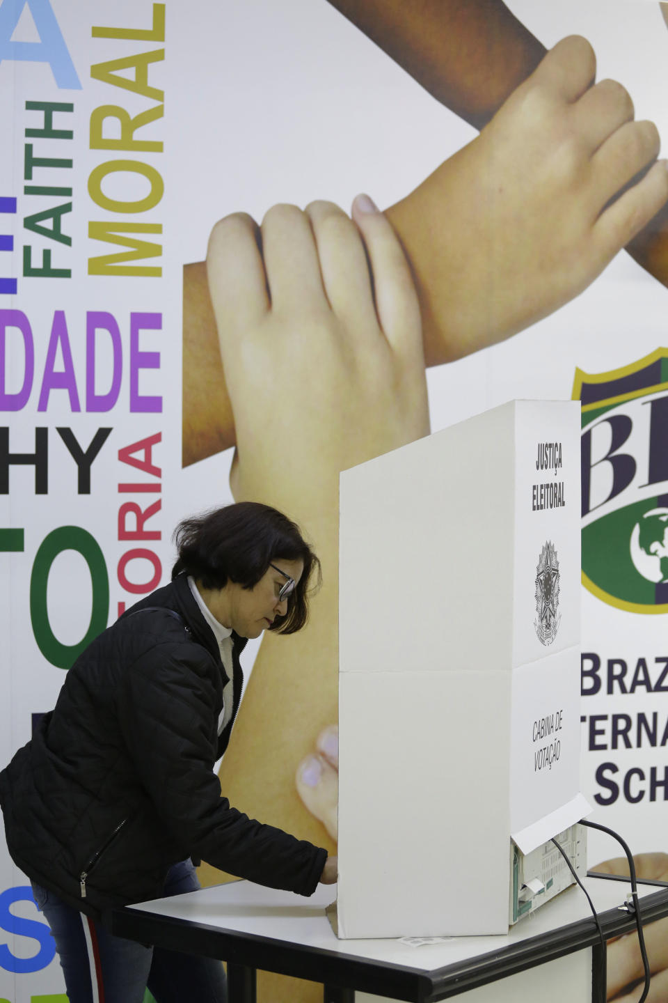 A woman casts her vote in the general elections in Sao Paulo, Brazil, Sunday, Oct. 7, 2018. Brazilians have started trickling to voting booths to choose leaders in an election marked by intense anger at the ruling class following years of political and economic turmoil. (AP Photo/Nelson Antoine)