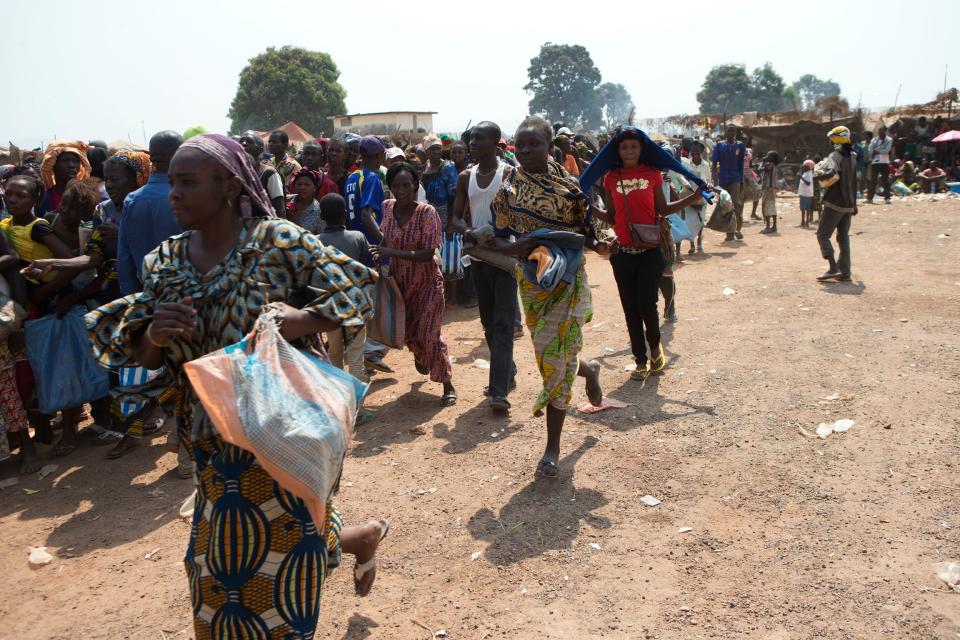 Women run to get in line as they enter a food and supplies distribution point, inside a makeshift camp housing an estimated 100,000 displaced people, at Mpoko Airport in Bangui, Central African Republic, Wednesday, Jan. 8, 2014. The distribution by the World Food Program and the United Nations Refugee Agency began Tuesday and was expected to last 10 days. It is the first aid delivery to reach the camp since Dec. 15, and many families were lacking food or even rudimentary shelter from the harsh daytime sun and chilly nights. Residents were receiving supplies including rice, cooking oil, tarps, mats, and blankets. (AP Photo/Rebecca Blackwell)