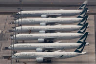 FILE - In this March 6, 2020, file photo, Cathay Pacific Airways aircrafts line up on the tarmac at the Hong Kong International Airport. Hong Kong airline Cathay Pacific Airways on Wednesday, Oct. 21, 2020, said it would cut 8,500 jobs and shut down its regional airline unit in a corporate restructuring, as it grapples with the plunge in air travel due to the pandemic. (AP Photo/Kin Cheung)