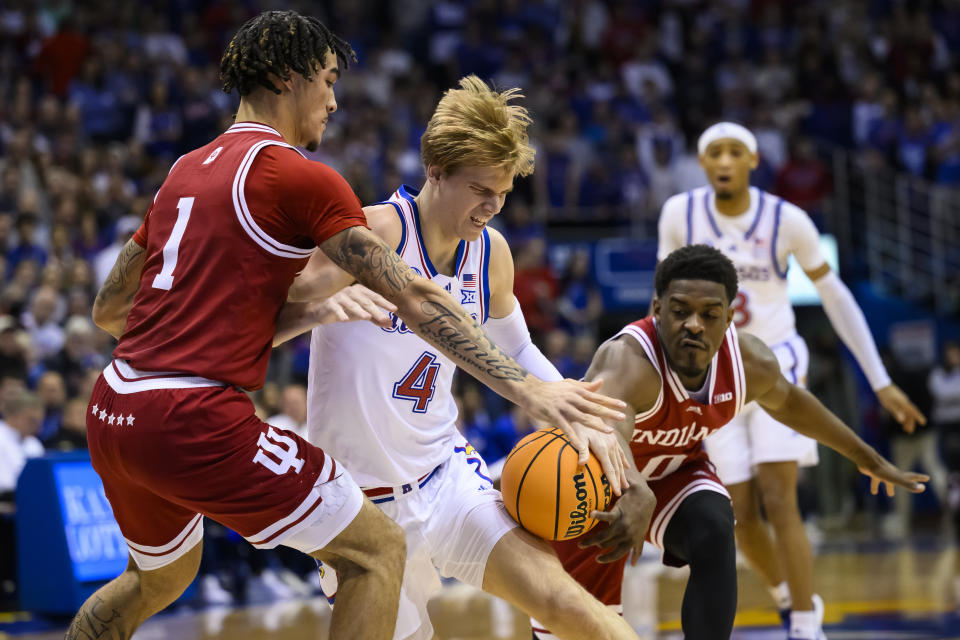 Kansas guard Gradey Dick (4) drives past Indiana guards Jalen Hood-Schifino (1) and Xavier Johnson (0) during the first half of an NCAA college basketball game in Lawrence, Kan., Saturday, Dec. 17, 2022. (AP Photo/Reed Hoffmann)