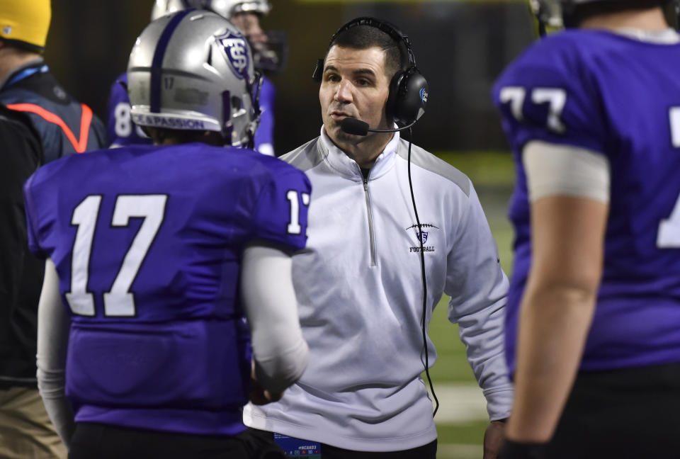 St. Thomas head coach Glenn Caruso instructs quarterback John Gould (17) in the second half against Mount Union in the NCAA Division III football championship game in Salem, Va., Friday, Dec. 18, 2015. (AP Photo/Michael Shroyer)