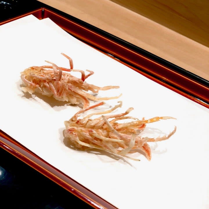 Two tempura prawns on a plate