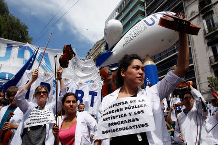 Thousands of teachers took to the streets, delaying the first day of school for millions of children, as part of a two-day national strike demanding a wage increase, in Buenos Aires, Argentina March 6, 2017. The signs read "In defence of public education, art and socio-educational programs." REUTERS/Martin Acosta