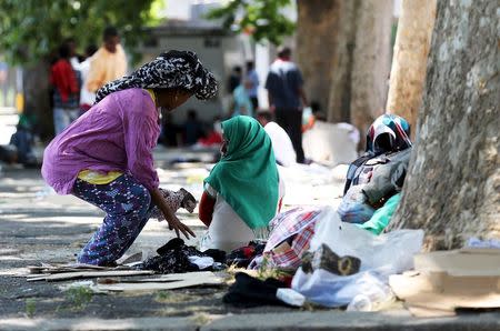 Women rest in a shady spot under trees next to the Tiburtina station in Rome, June 11, 2015. REUTERS/Alessandro Bianchi