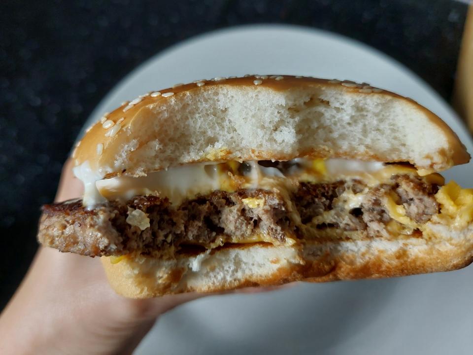 Photo of a Quarter Pounder with Cheese from McDonald's, held above a plate, that has been bitten into, taken in July 2024