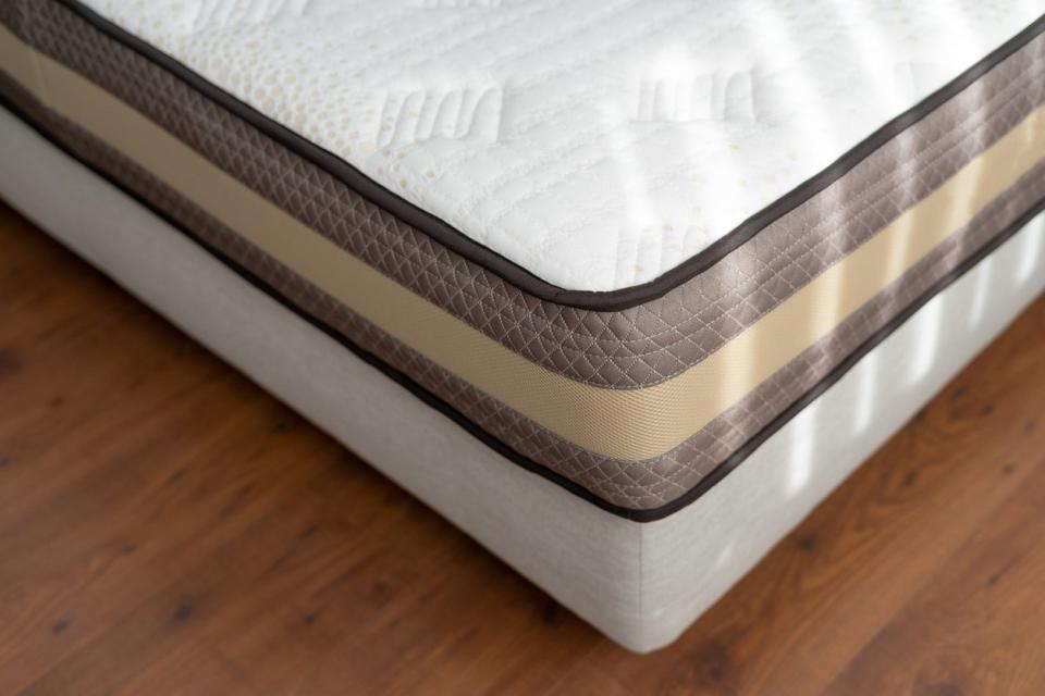 Healthy sleeping concept. Selective focus at part of new orthopedic mattress with memory foam or coconut fiber. Comfortable bed in hotel room and modern apartment