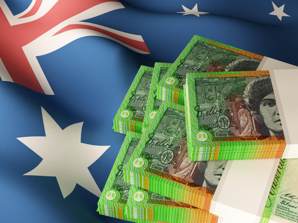 Australian dollar banknote bundles on textile textured Australia flag. Source: Getty Images