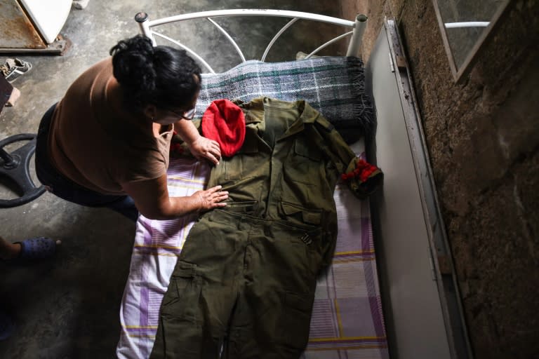 Josefina Cortes shows the school band's uniform of her missing son Charli Rodriguez, at her house in Jose Cardel, Mexico's Veracruz state