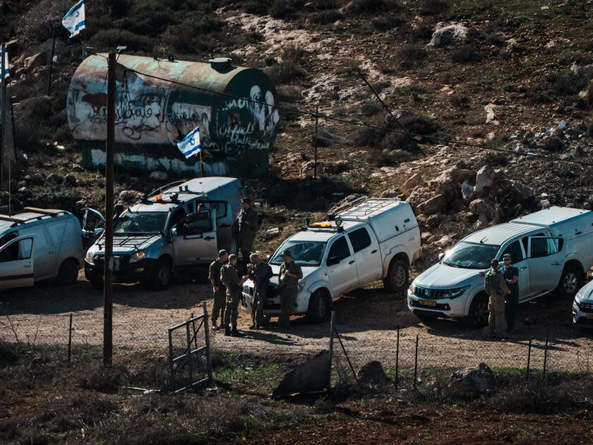 People and trucks blocking a dirt road