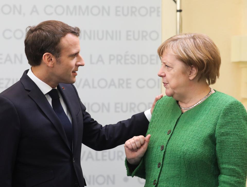 France's President Emmanuel Macron (L) and German Chancellor Angela Merkel (R) speak prior to a working session of European leaders at a EU summit in Sibiu, central Romania on May 9, 2019. (Photo by Ludovic MARIN / POOL / AFP)        (Photo credit should read LUDOVIC MARIN/AFP/Getty Images)