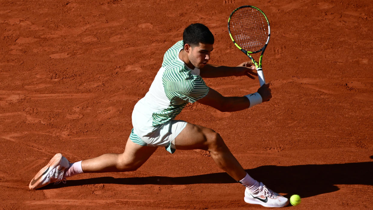  Carlos Alcaraz stretches for a backhand on clay at the French Open 