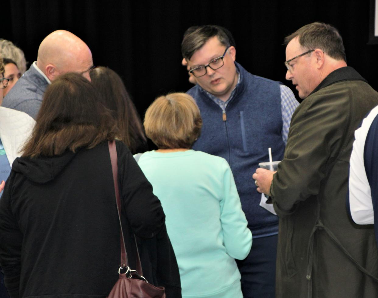 Jesse Montgomery, center, president of development for the  National Renewable Energy Corporation, talks to Pleasant Township residents about the proposed Chestnut Solar LLC project during a public meeting on Tuesday, Dec. 6, 2022, at Tri-Rivers Career Center. The company is planning to build a 68 megawatt solar energy generation facility in Pleasant Township.