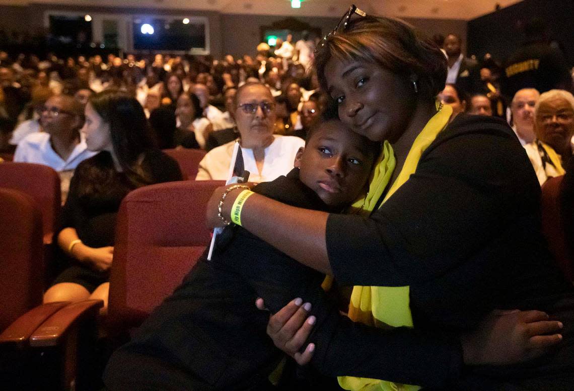 Mikaben’s son Gabriel Benjamin hugs his mother, Anne-Catherine Richard, during a memorial service for Haitian singer Mikaben at the Civic Center Plaza in Miramar on Sunday.