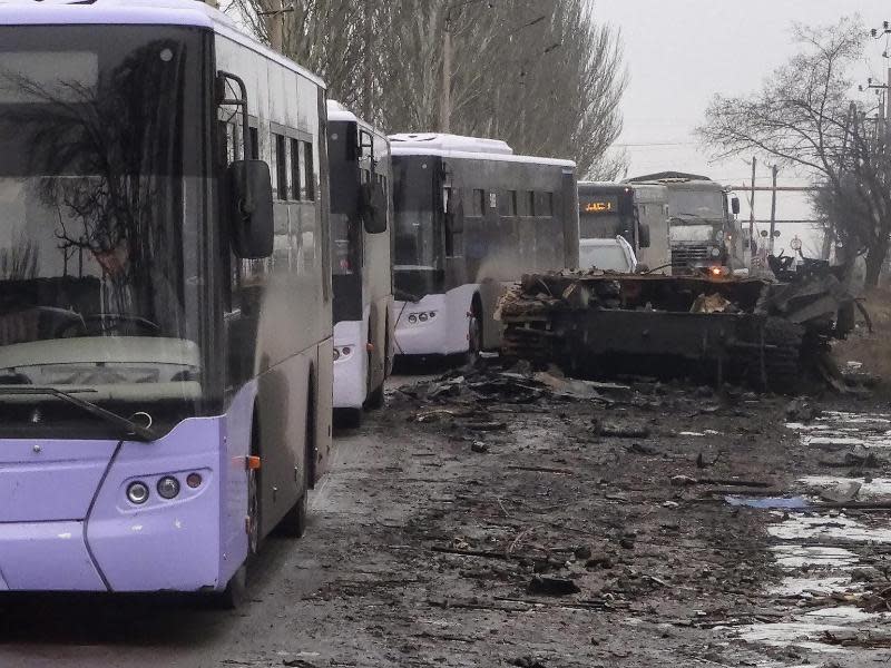 Flüchtlingsbusse bahnen sich nahe der umkämpften Stadt Debalzewo ihren Weg neben einem zerstörten Panzer. Foto: Vladimir Vladimirov