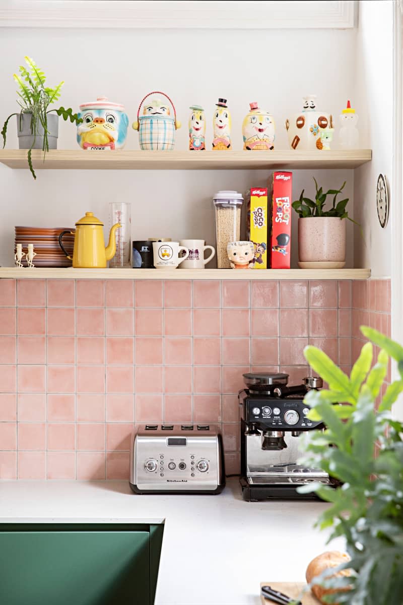 Pink tile backsplash in newly renovated kitchen with open shelves.