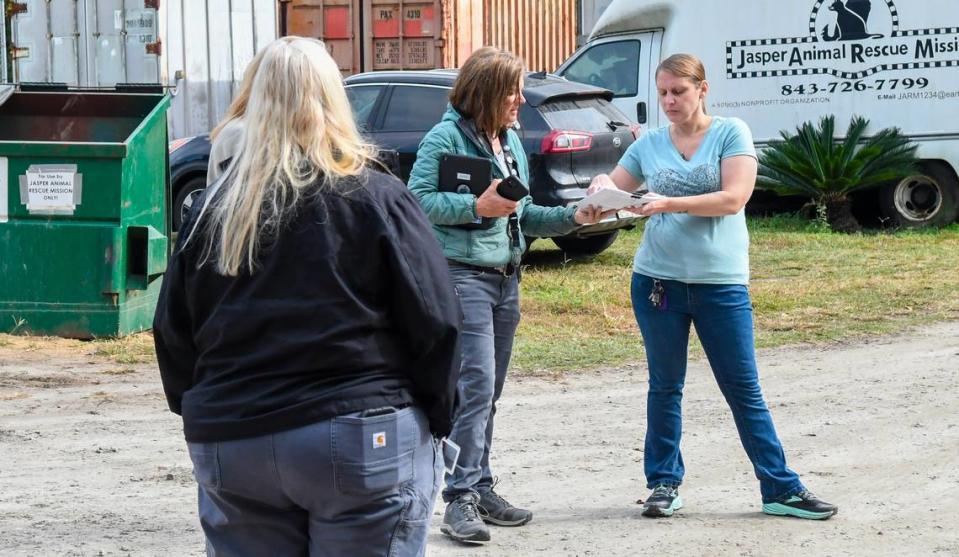 Tallulah Trice, Beaufort County Animal Services and Control Director, center, hands Caitlyn Schake, Jasper Animal Rescue Mission’s Executive Director a 553 statement checklist produced by the Association of Shelter Veterinarians Guidelines for Standards of Care in Animal Shelters on Monday, Nov. 13, 2023 in Ridgeland. While not a legal document, the checklist was given to JARM’s director to measure the shelter’s operations against the recommendations for standards in care in animal shelters. Standing with the group is Rose Dobson-Elliott, back to the camera, Jasper County’s Director of Engineering Services and Franny Gerthoffer, not visible, Hilton Head Humane Association’s Director.